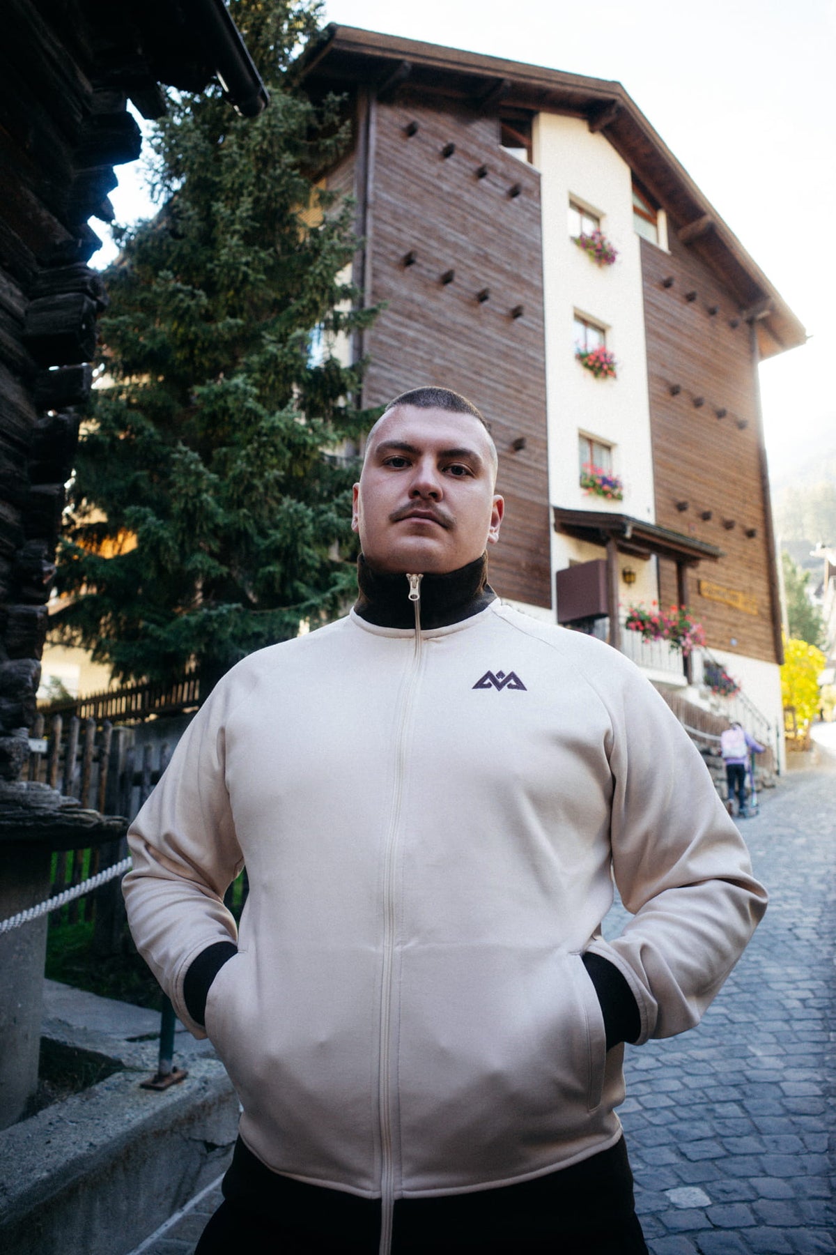 Frontansicht der cremefarbenen Trainingsjacke mit Logo