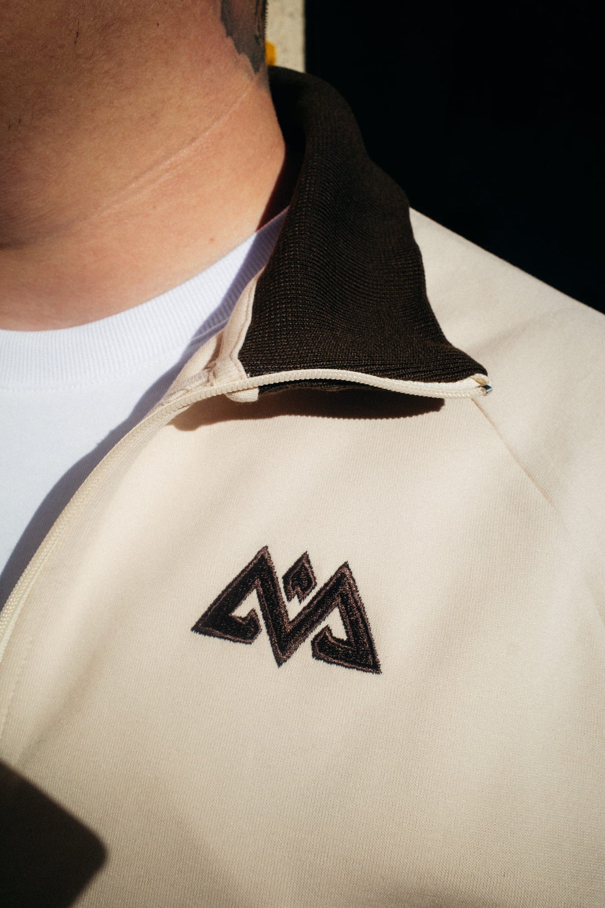 Nahaufnahme Kragen und Logo der Cappuccino Trackjacke