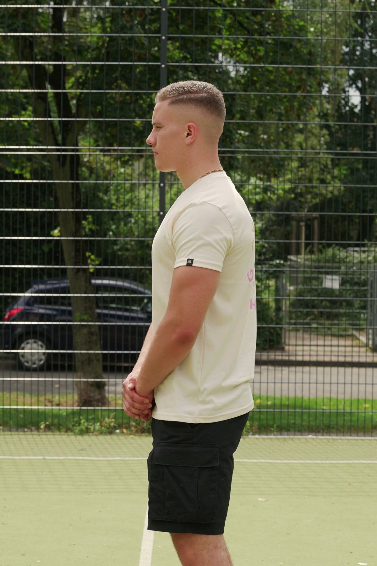Side view of pastel peach t-shirt showing woven sleeve label