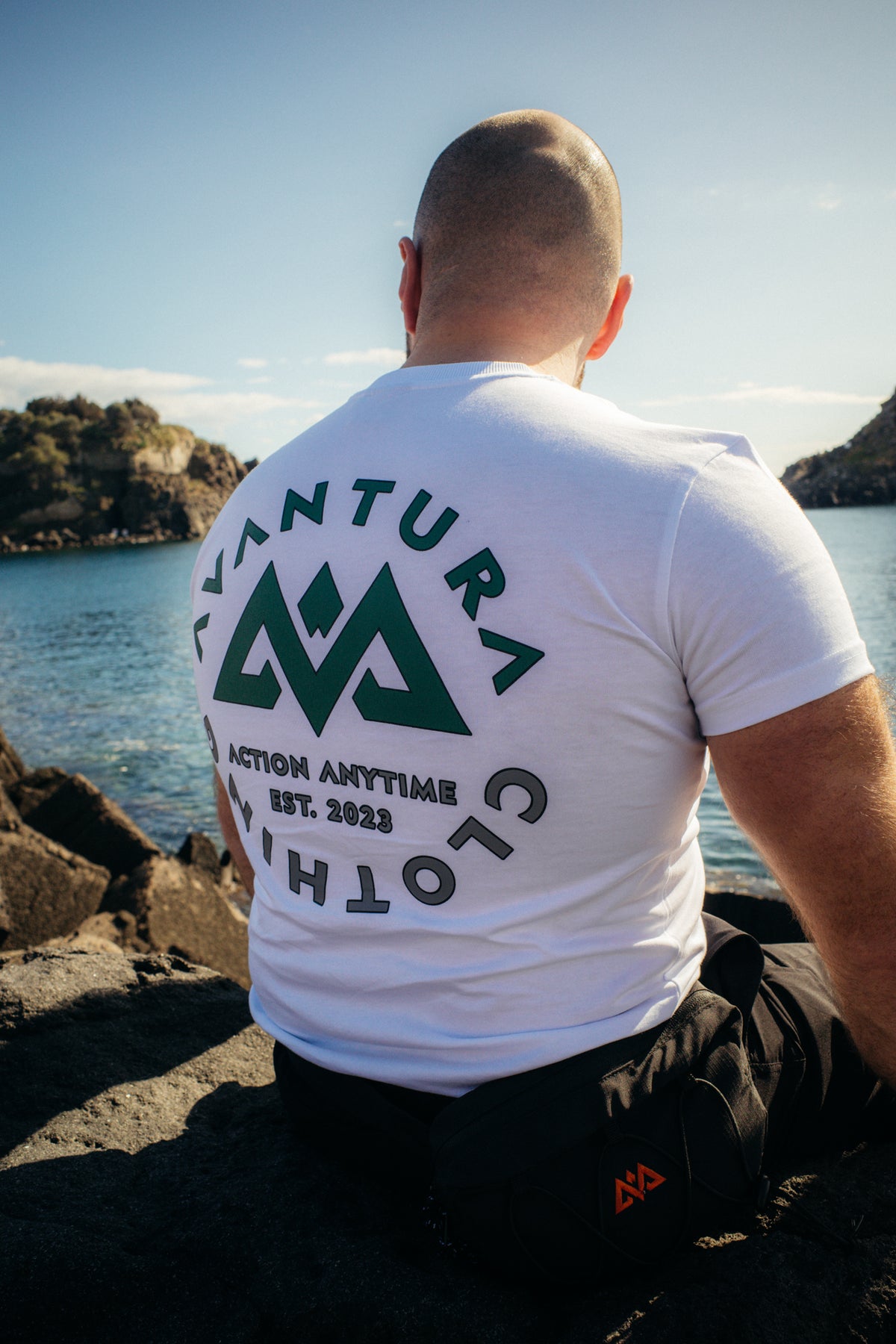 White t-shirt worn outdoors showing detailed green graphic back design