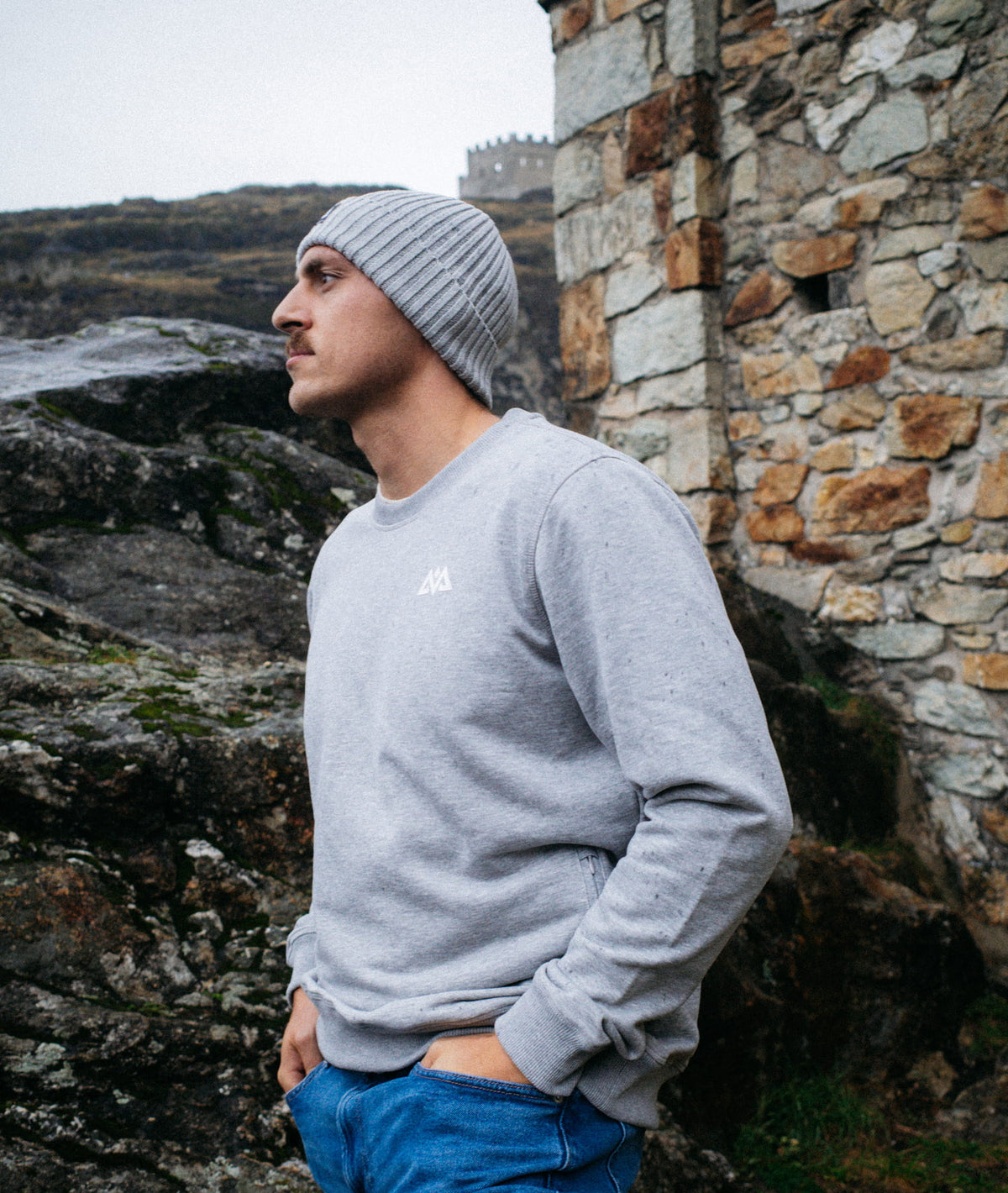 Seitenansicht des grauen Sweatshirts mit sichtbarer Reißverschlusstasche