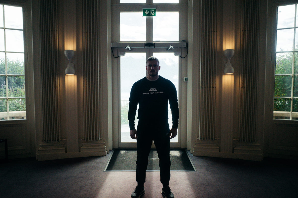 Frontalansicht schwarzer Langarm Pullover mit weißem BORN FOR ACTION Print