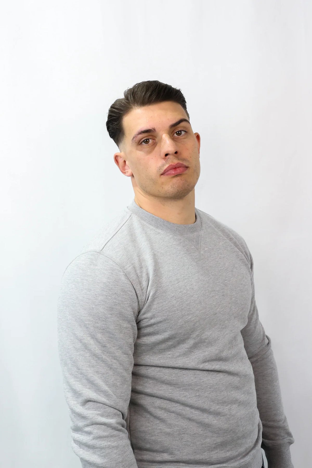 Grey crewneck sweatshirt featuring ribbed neckline with V-stitch detail