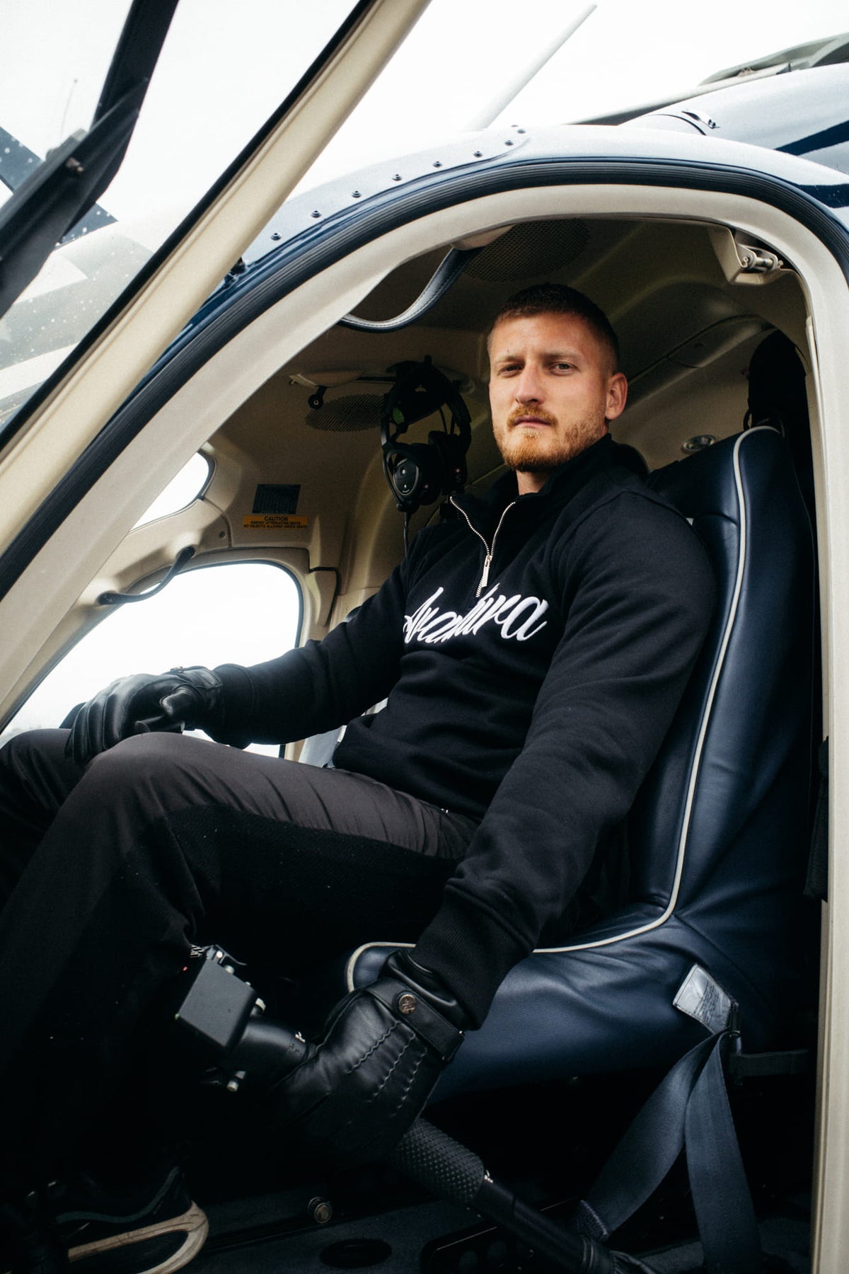 Black Avantura sweatshirt in a helicopter cockpit