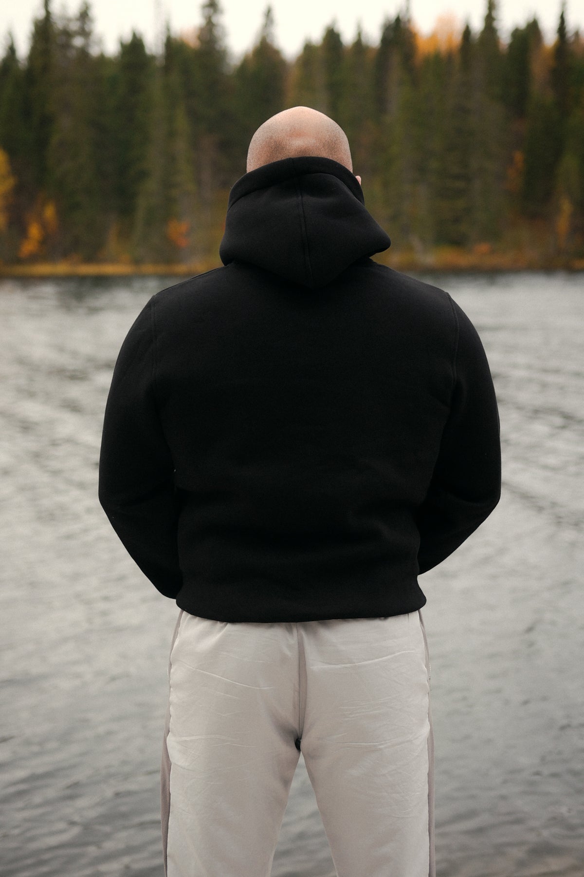 Mann trägt schwarzen Kapuzenpullover ohne Aufdruck im Outdoor-Setting