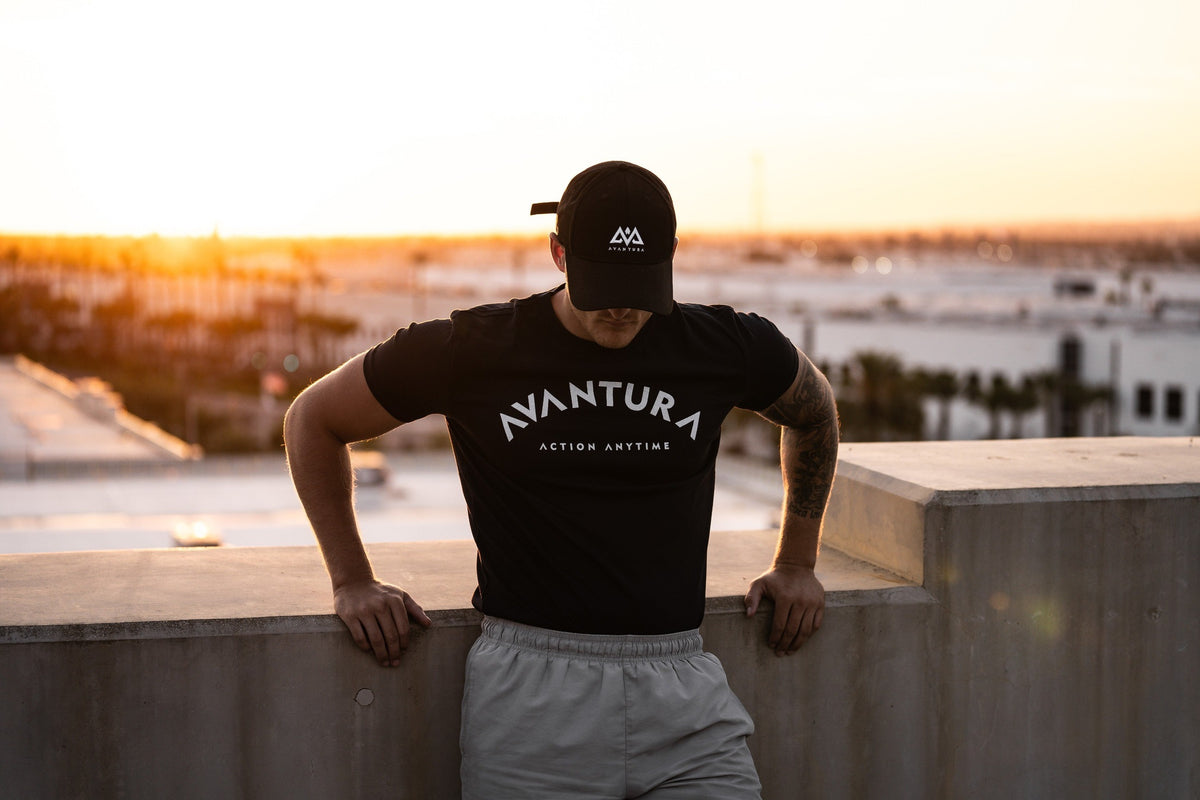 Dunkelblaues T-Shirt mit gebogenem AVANTURA Flockdruck im urbanen Setting