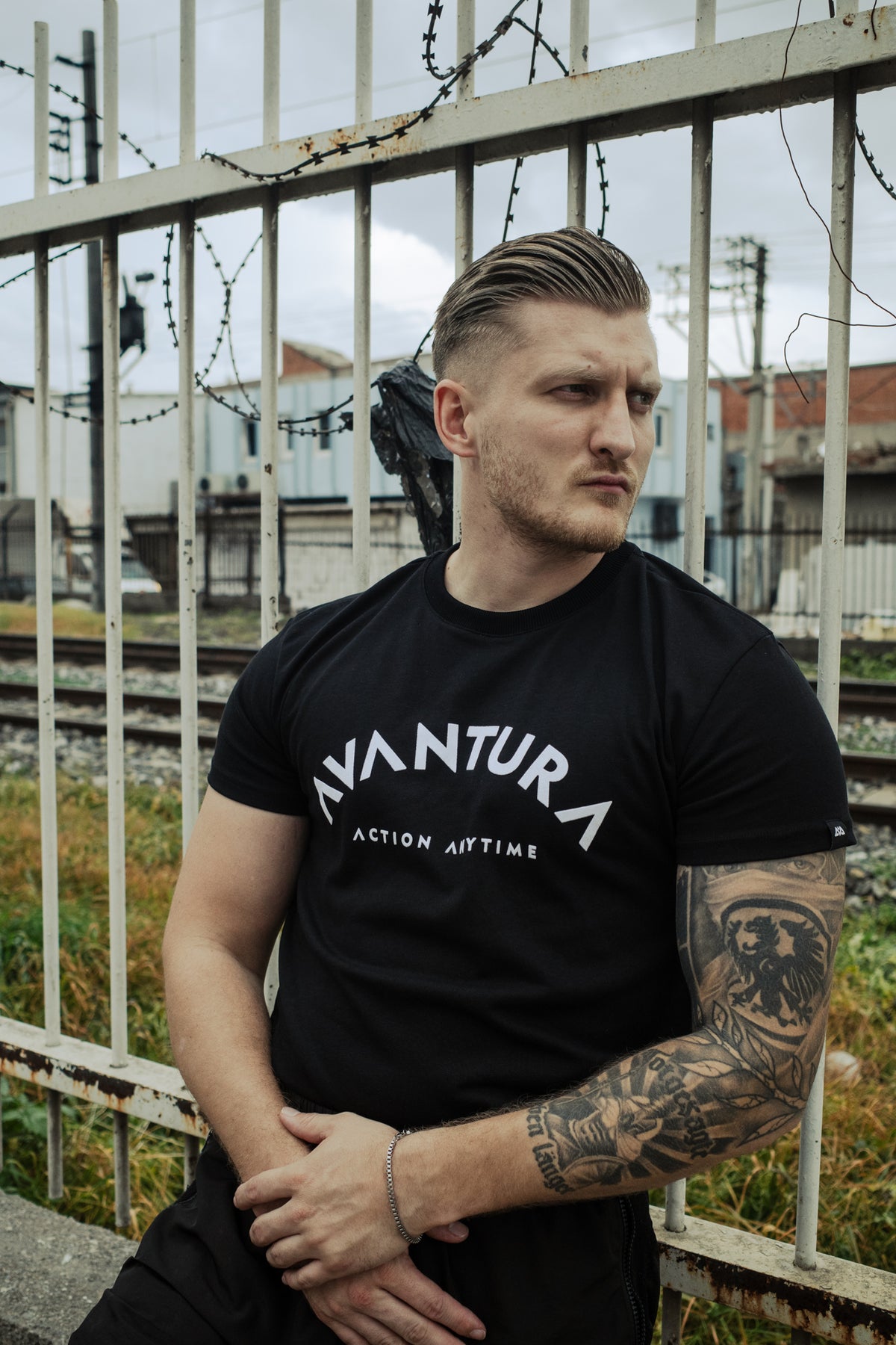 Fitted black T-shirt with triangular 'A' design in curved 'AVANTURA' chest lettering