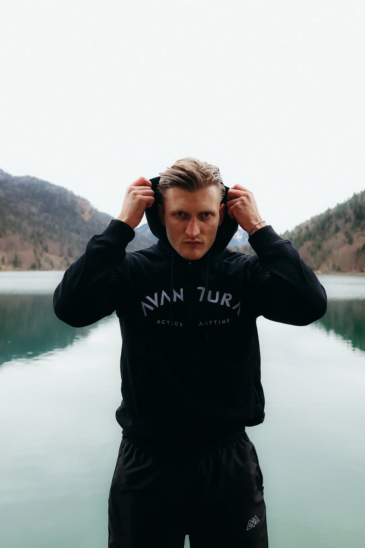 Black zip-up hoodie with curved AVANTURA text and front pocket