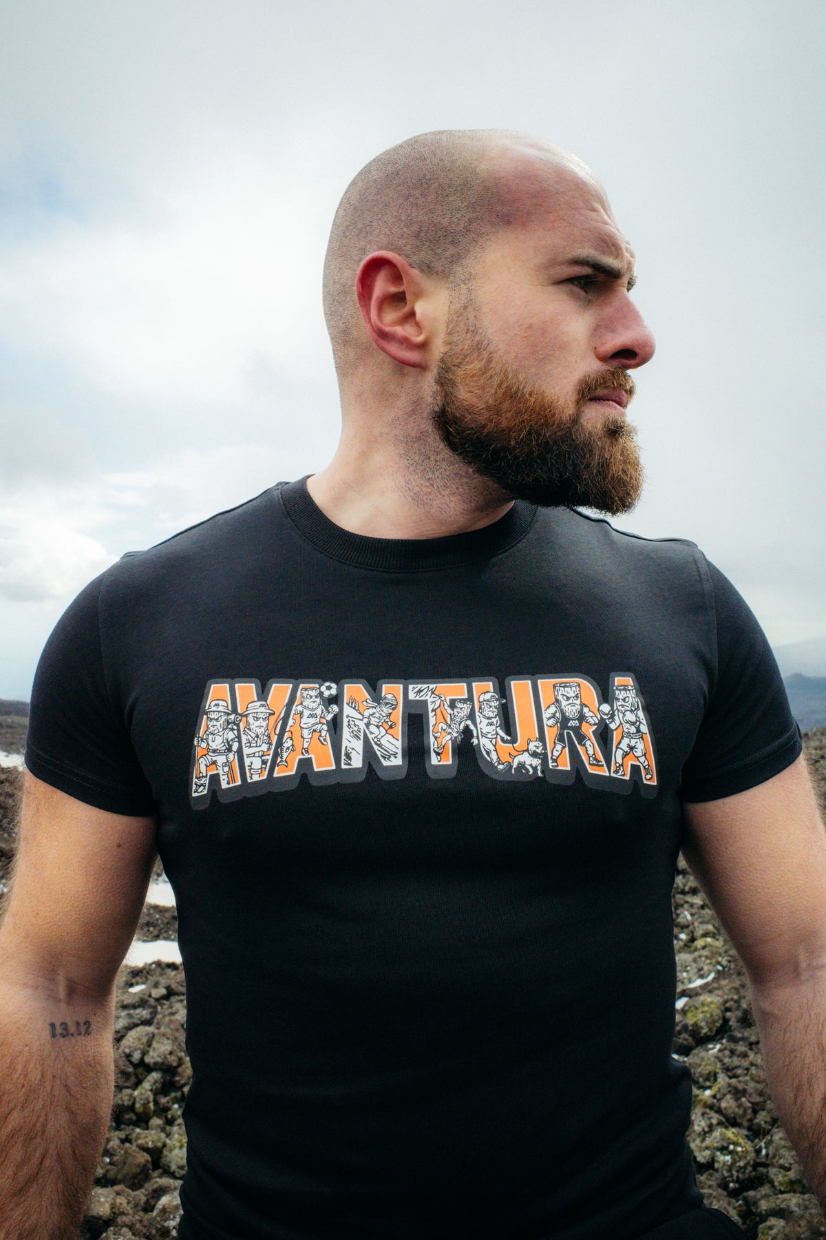 Black Avantura t-shirt with orange and white Viking graphic print on chest