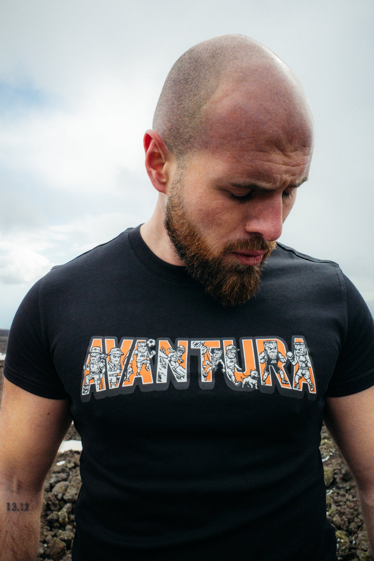 Detailed view of black crew-neck t-shirt with adventurer-filled AVANTURA print