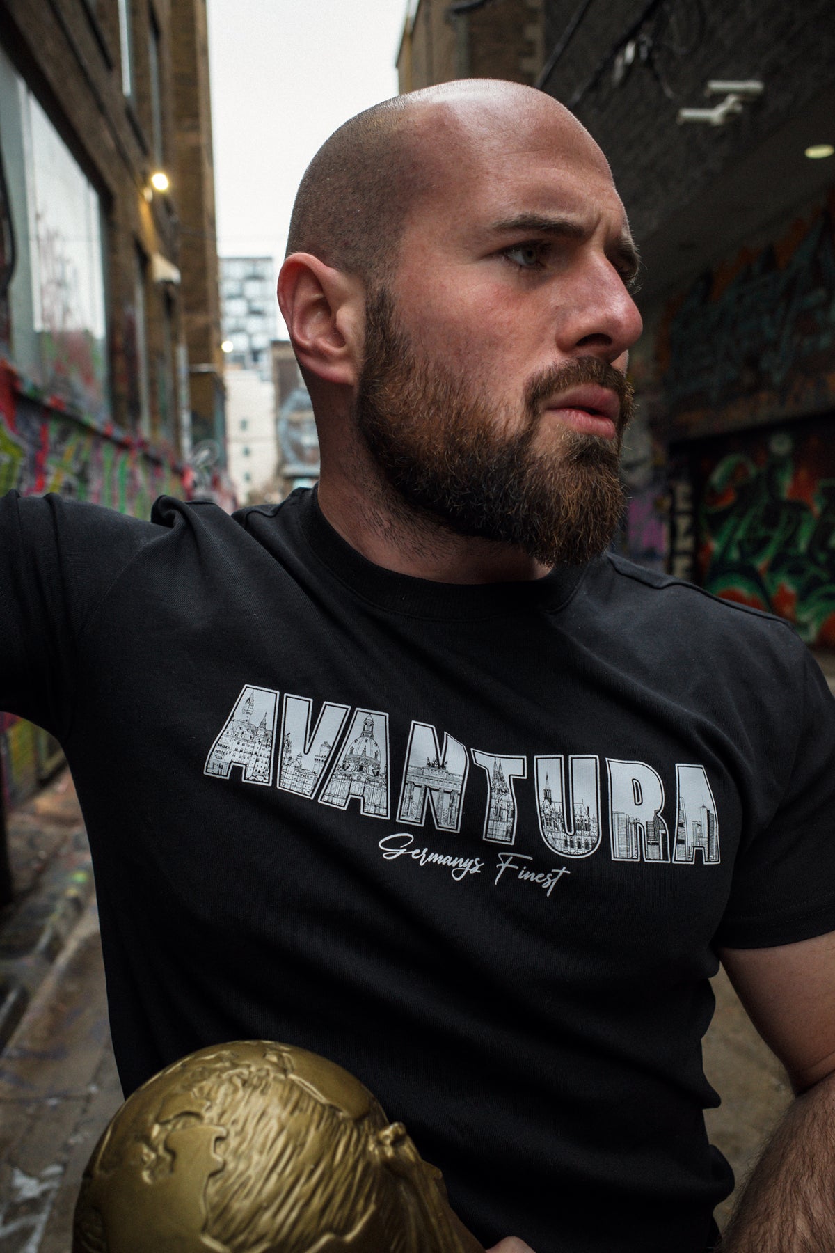 Schwarzes T-Shirt mit gefülltem AVANTURA-Logo und Stadtsilhouetten
