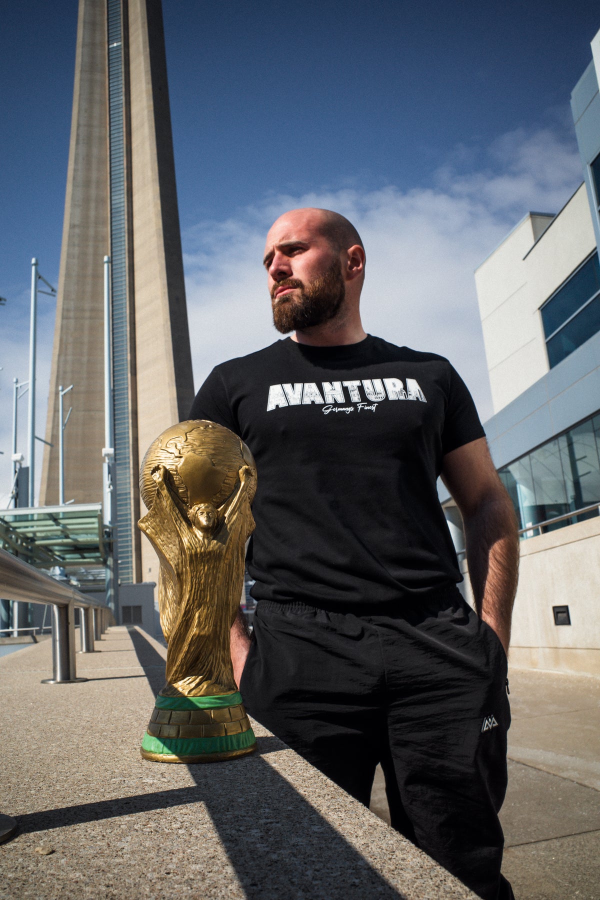 Avantura T-Shirt Schwarz mit Logo Print neben goldenem Pokal