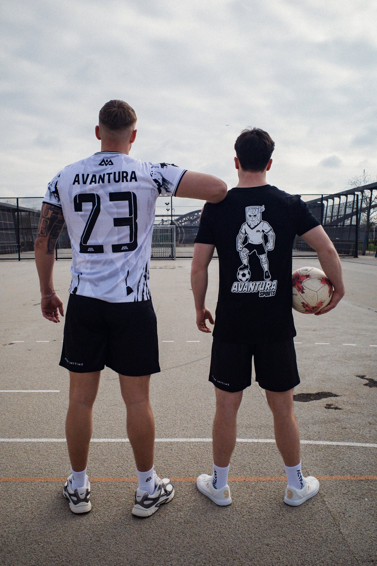 Two men on court wearing black and white Avantaura Sports athletic shirts