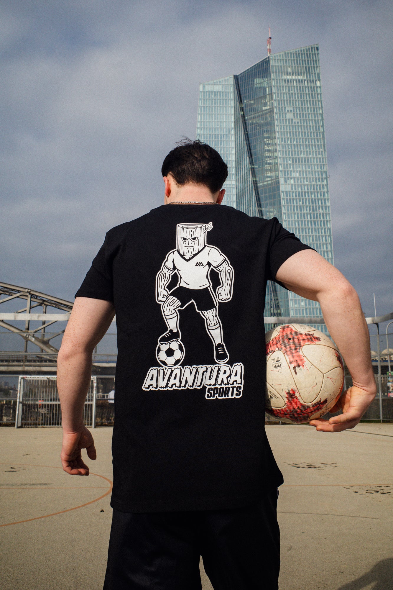 Urban street style black T-shirt with stylized log-headed soccer player back design