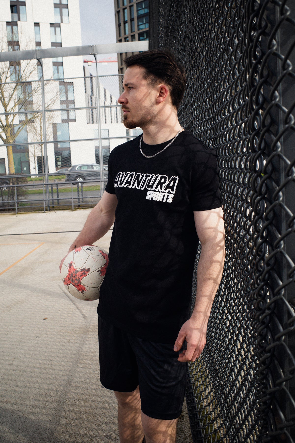 Profile shot of man wearing black T-shirt with distressed white chest lettering