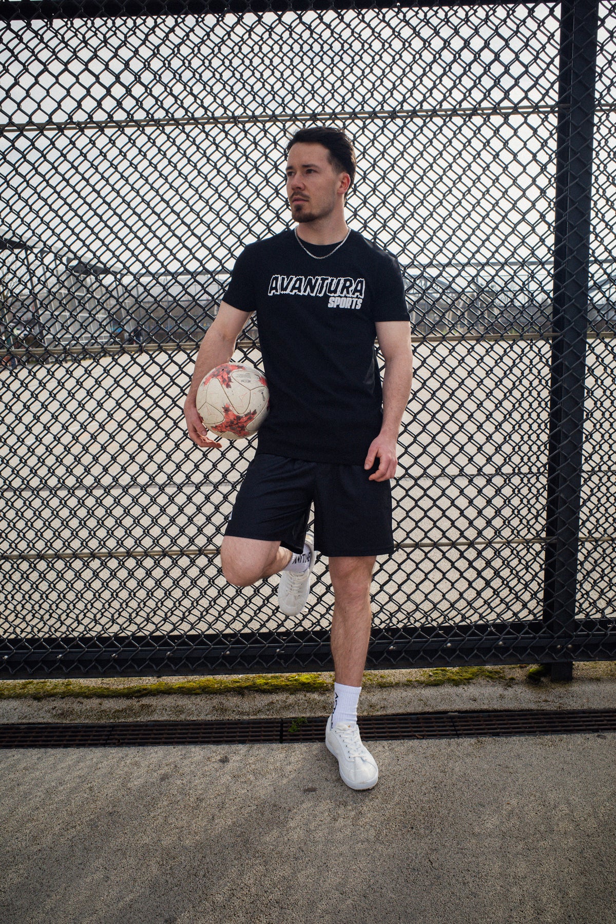 Full body view of man in black Avantaura Sports T-shirt and athletic shorts