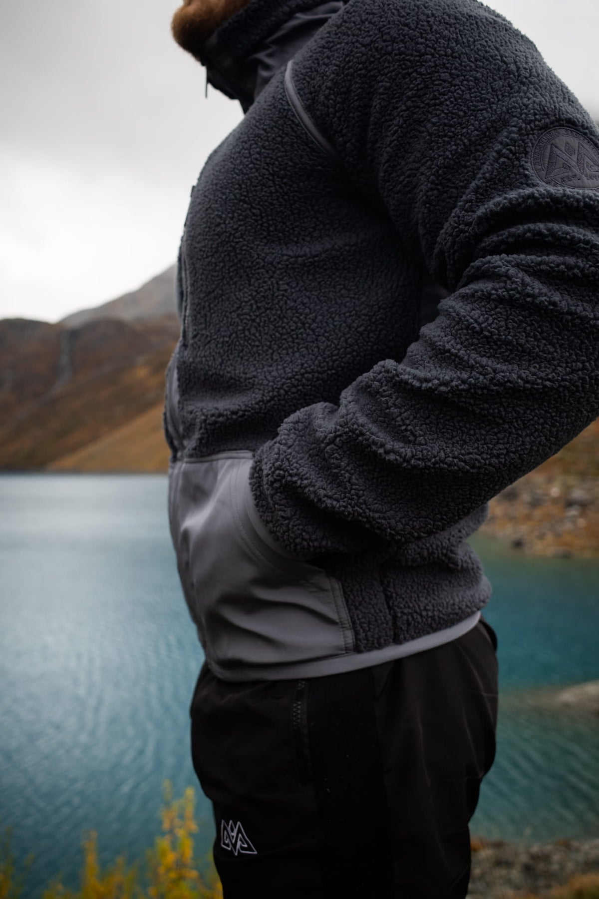 Seitentasche der grauen Fleecejacke mit glattem Stoffeinsatz