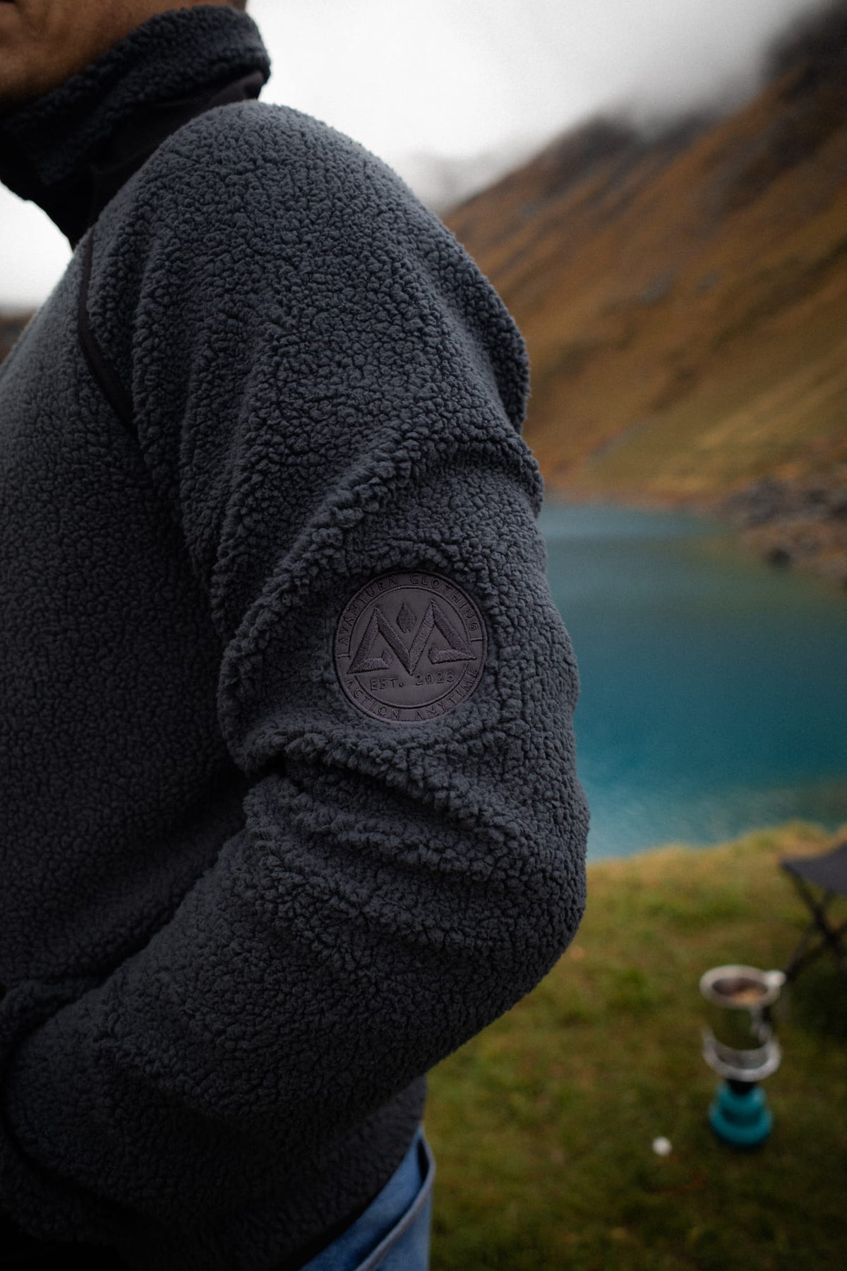 Logopatch am Ärmel der grau-schwarzen Fleecejacke mit Bergsymbol