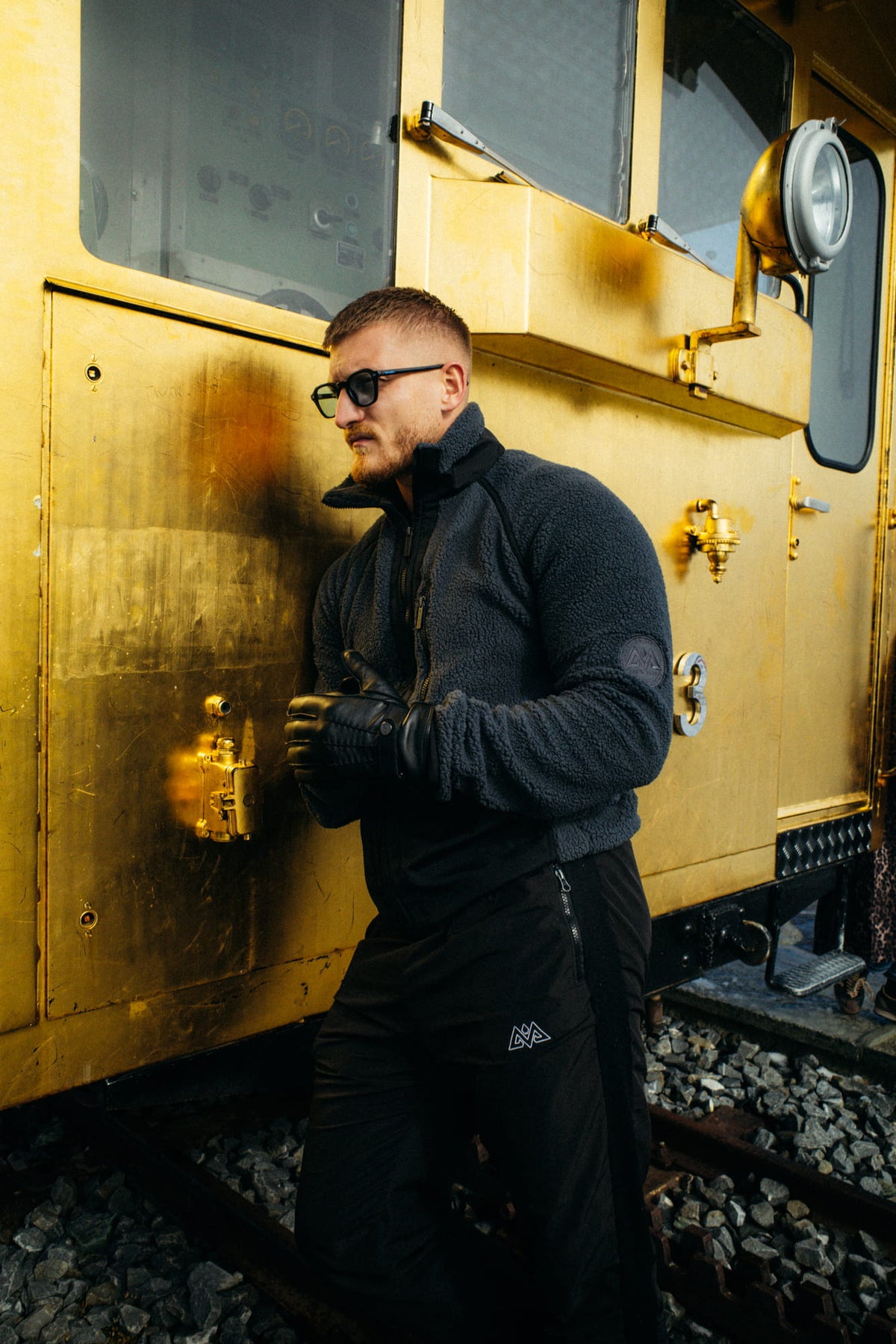 Fleecejacke Grau/Schwarz im Outdoor-Stil mit Sonnenbrille und Handschuhen