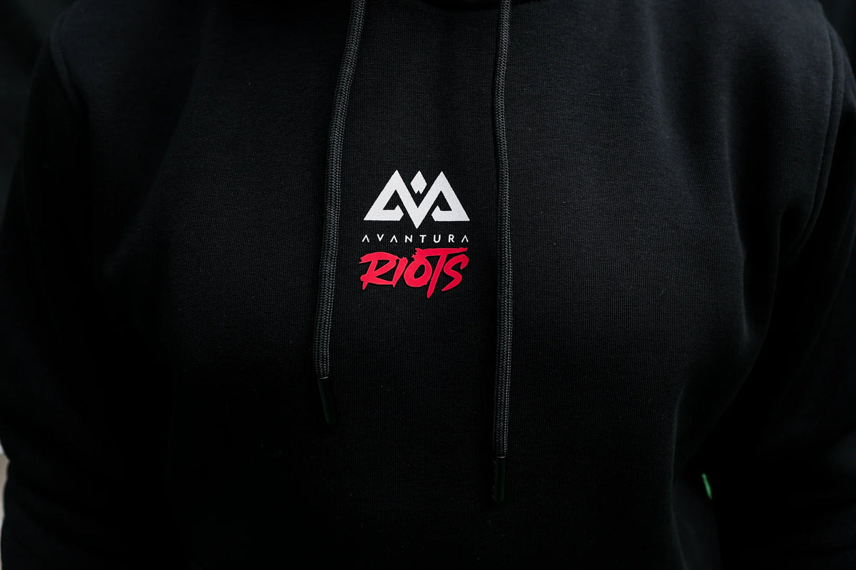 Black Avantura hoodie chest detail with white geometric logo and red RIOTS print