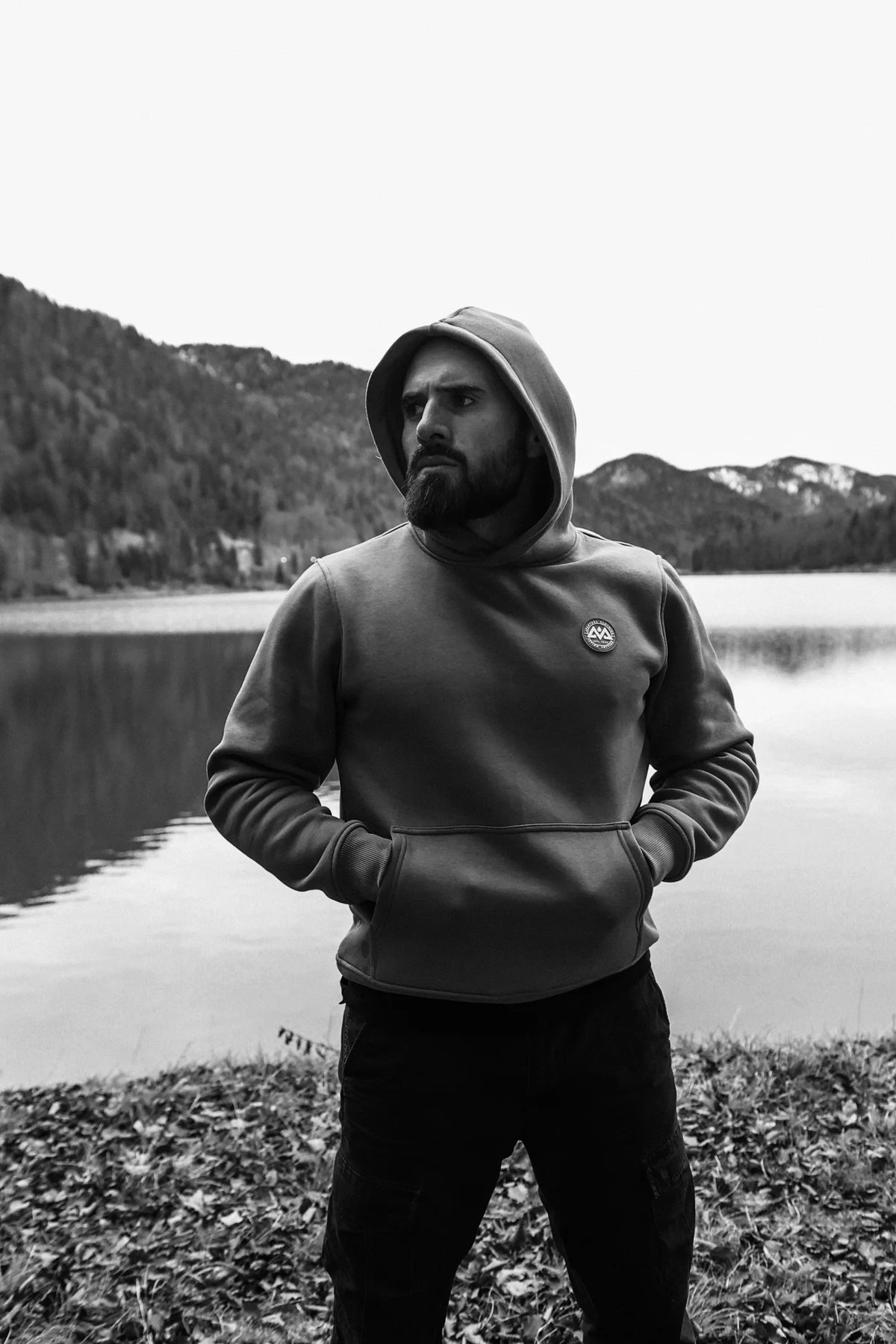 Grauer Hoodie mit hochgezogener Kapuze und Händen in der Tasche