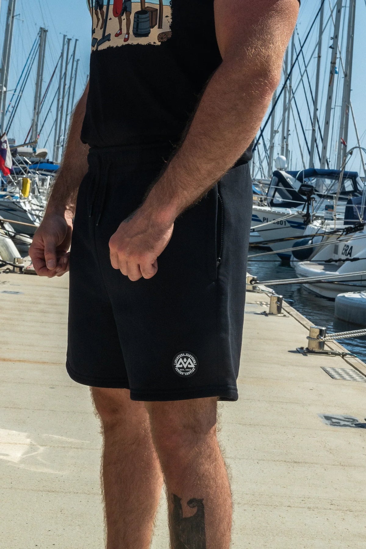 Man wearing black shorts at marina