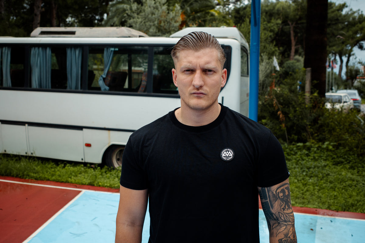 Avantura T-Shirt Schwarz mit weißem Rundlogo getragen