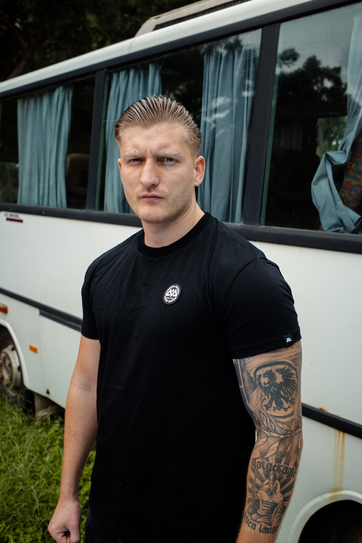 Mann trägt schwarzes Avantura T-Shirt mit weißem Brustlogo