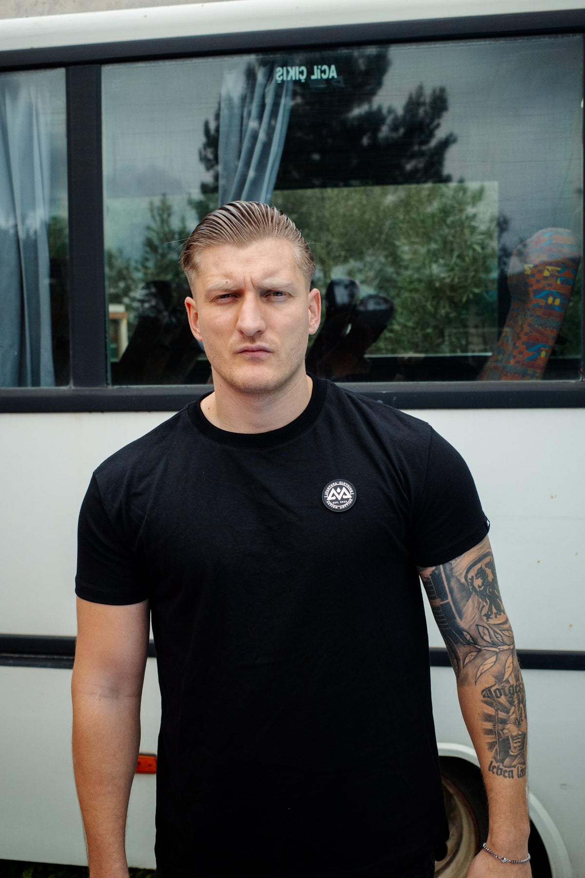Schwarzes T-Shirt mit rundem weißen Logo auf der Brust