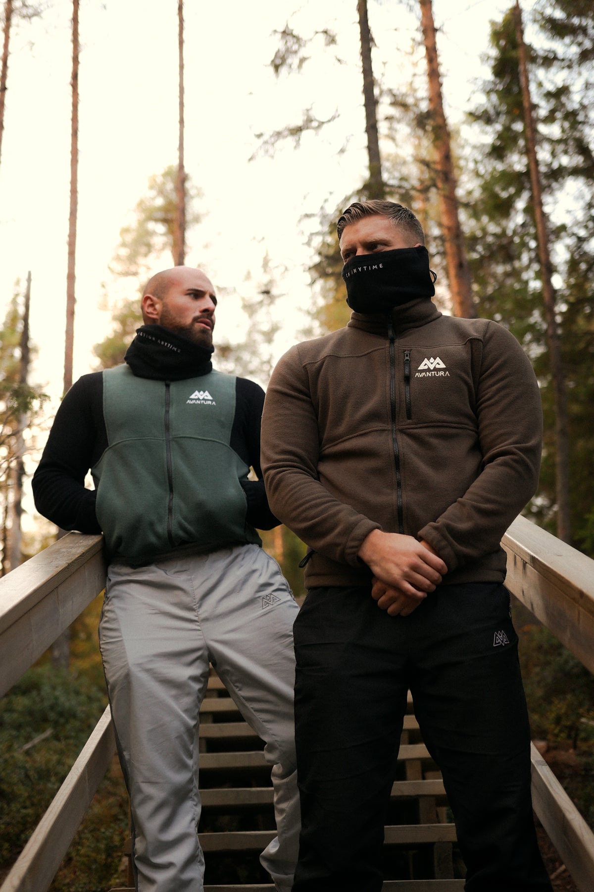 Men wearing brown and green Avantura fleece jackets in forest setting