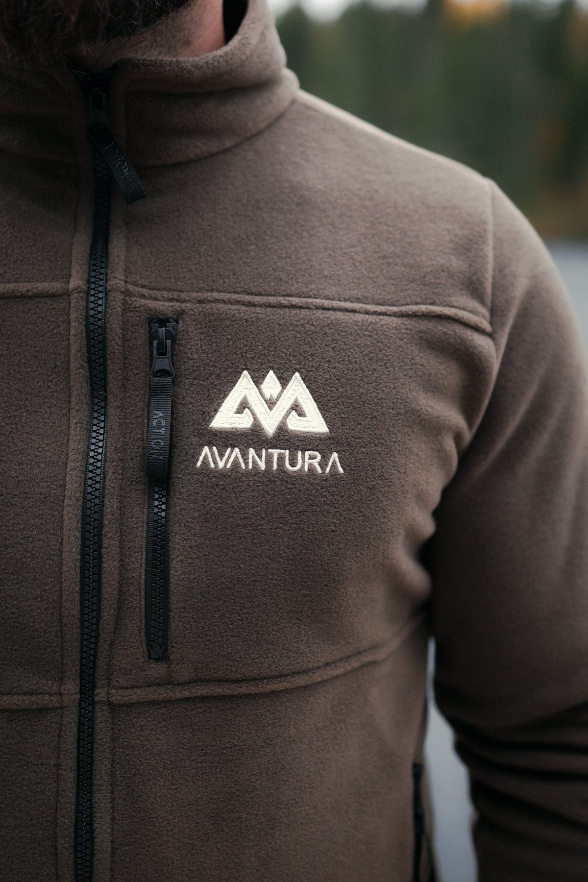 Detail of brown fleece texture, zipper, and embroidered Avantura logo