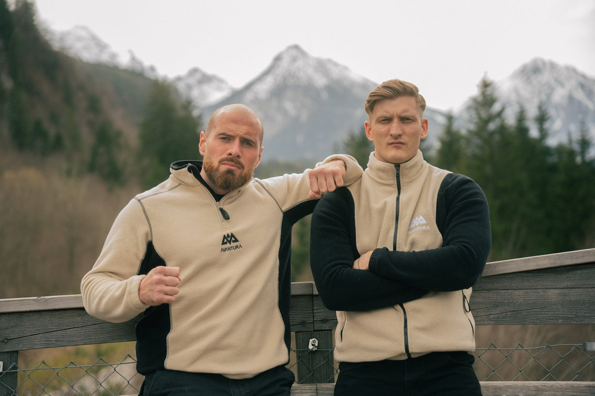 Beige-schwarzer Halfzip Fleecepullover mit gesticktem Logo in verschneiter Bergkulisse