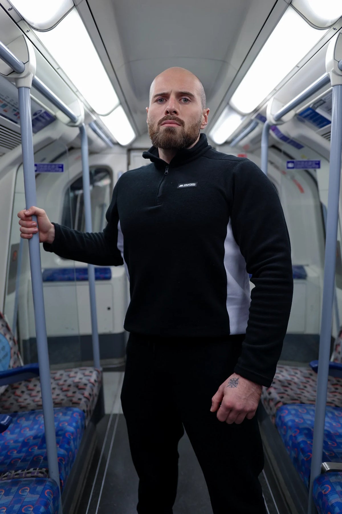 Man modeling black half-zip fleece with white side panels