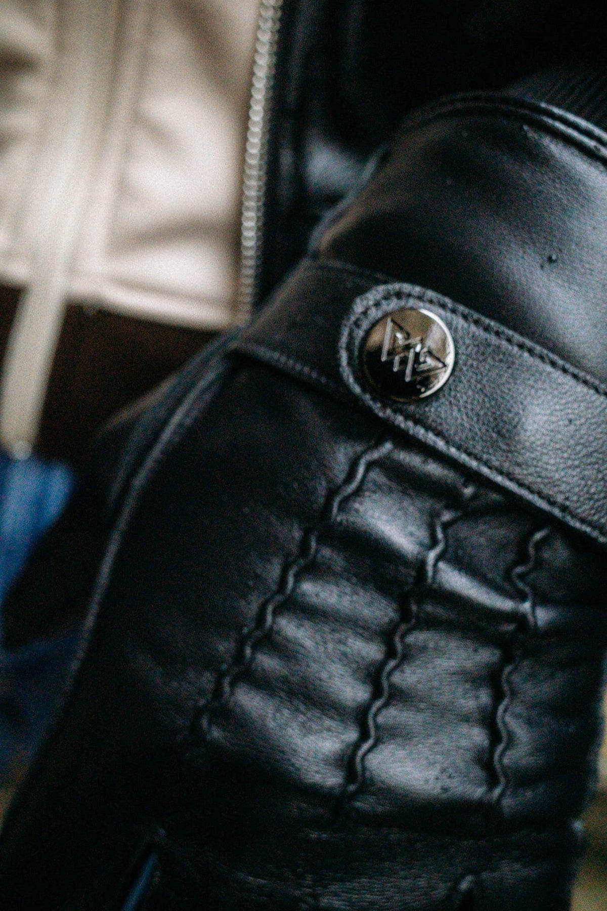 Makroaufnahme Lederstruktur und Logo-Schnalle am Handschuh