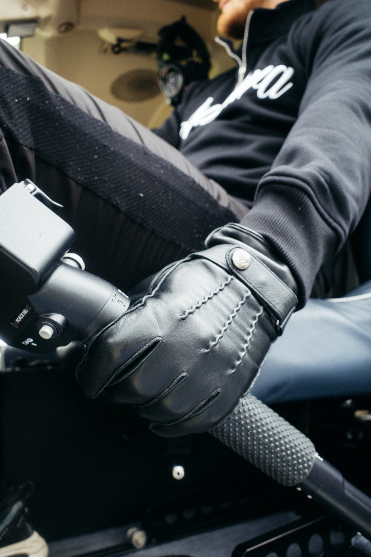 Griff im Auto mit texturiertem schwarzen Lederhandschuh