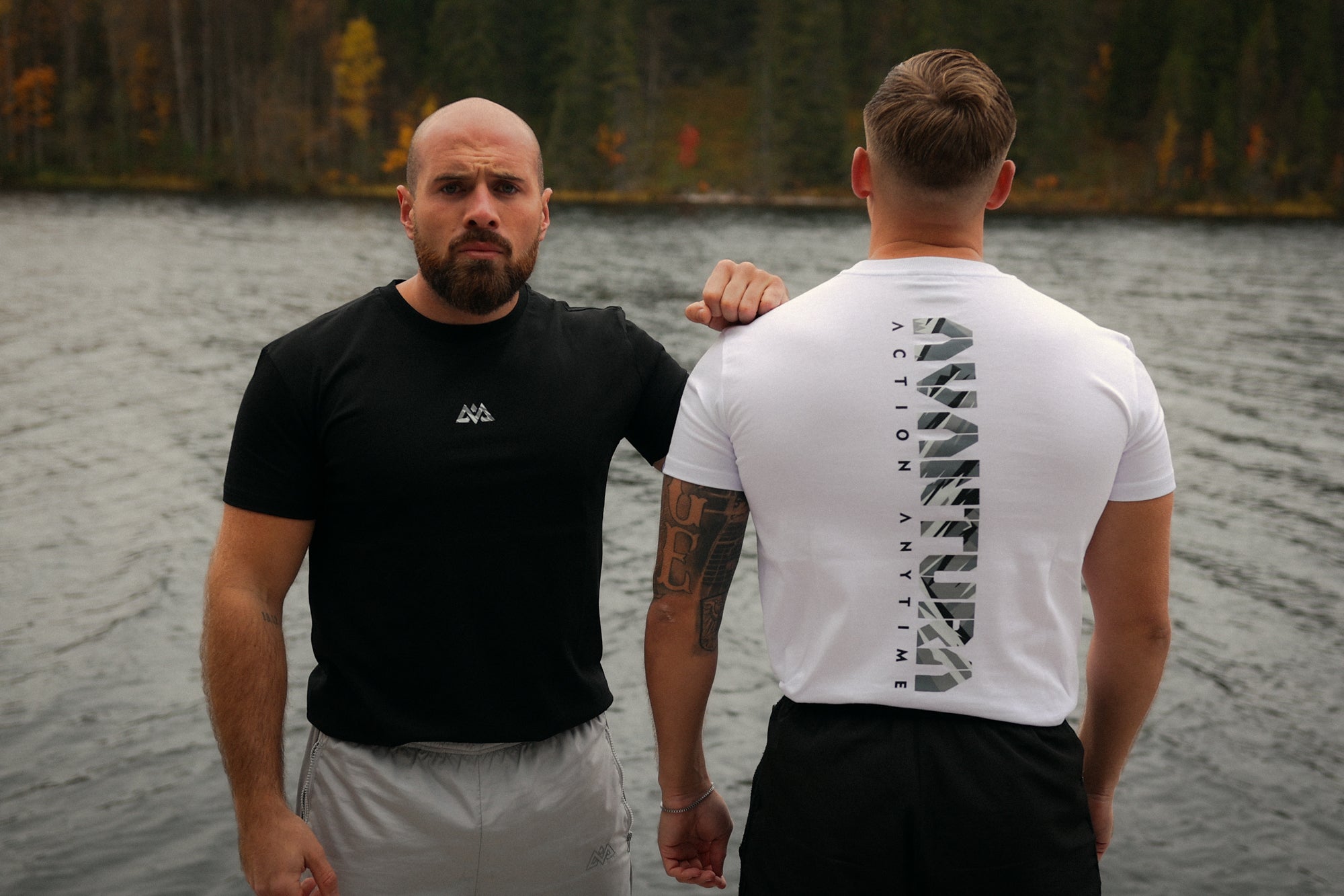 Men wearing black and white Avantura T-shirts near lake