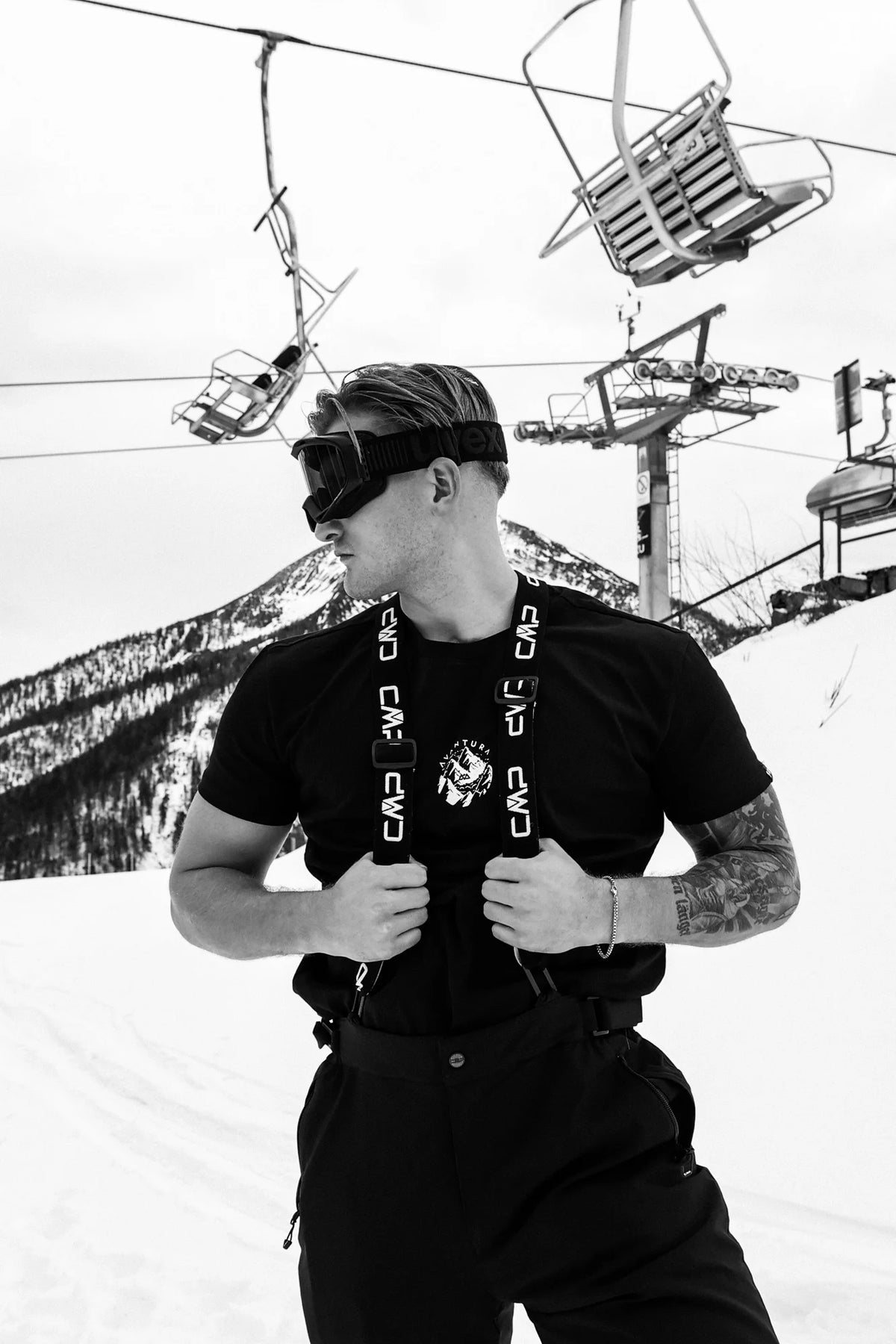 Black T-shirt with small chest logo worn with suspenders