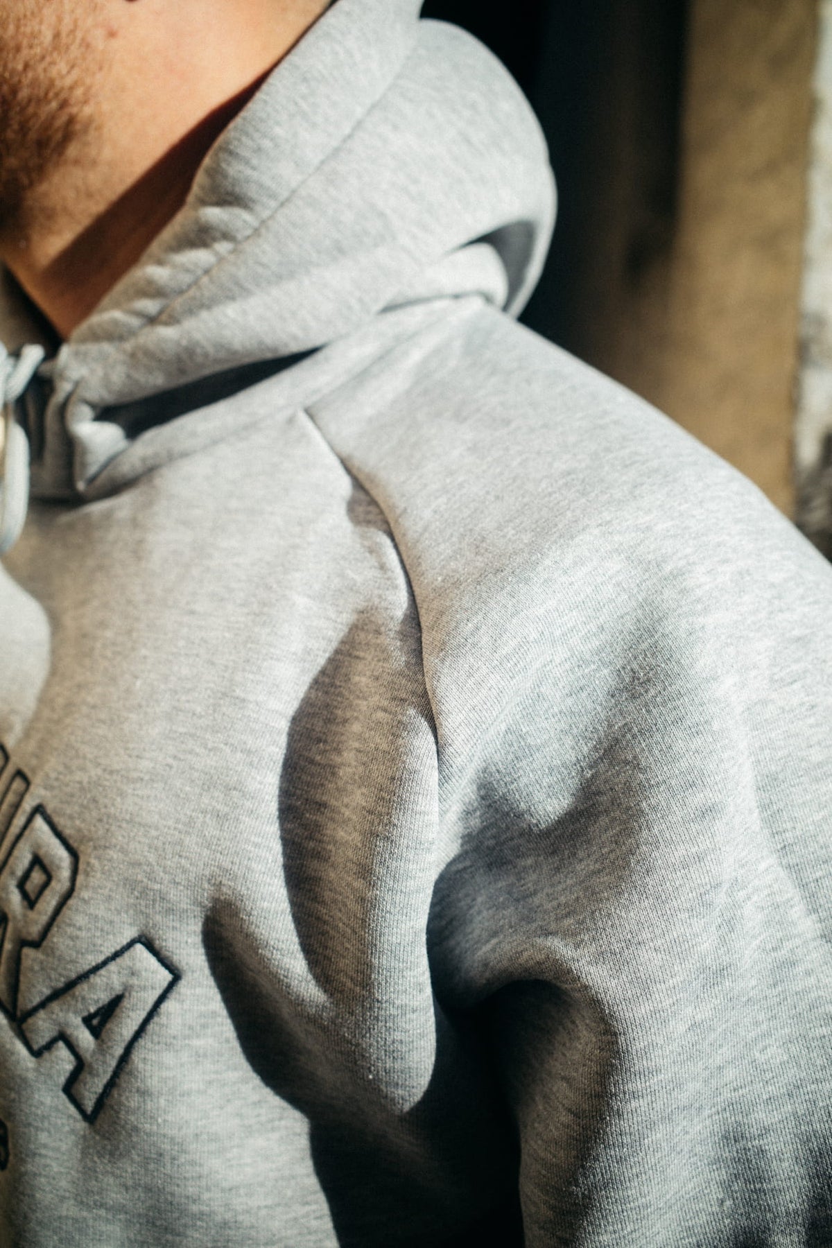 Nahaufnahme grauer Hoodie Kragen und Schulterpartie mit Raglan-Schnitt