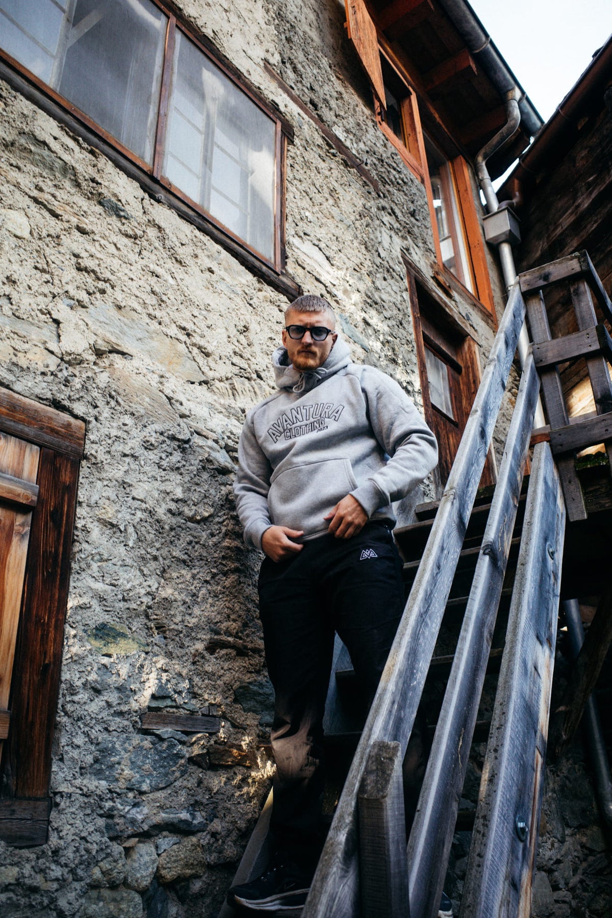 Grauer Outline Hoodie mit Brustaufdruck, kombiniert mit schwarzer Hose