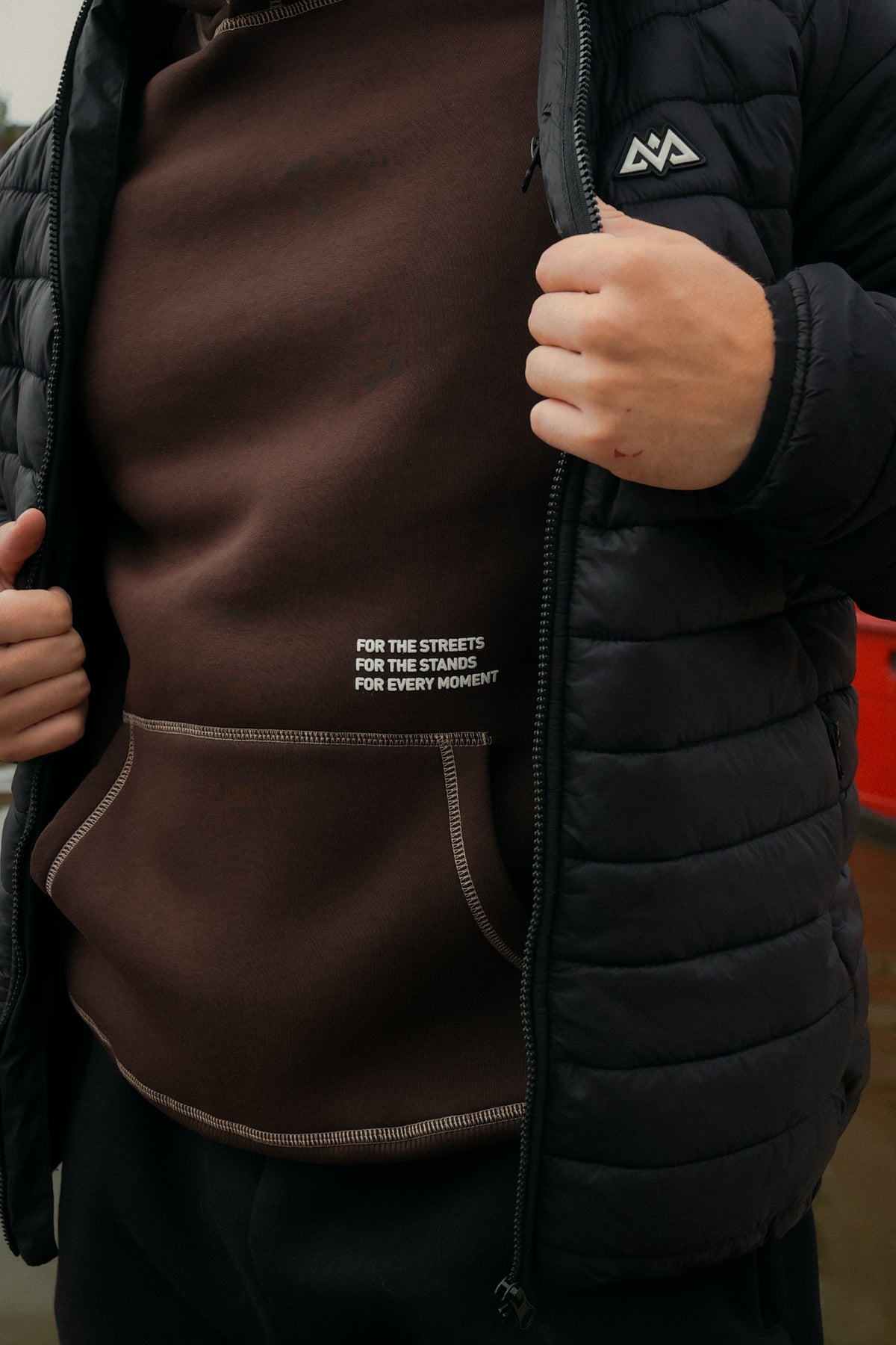 Brown oversized hoodie with white puff print text and light brown contrast seams
