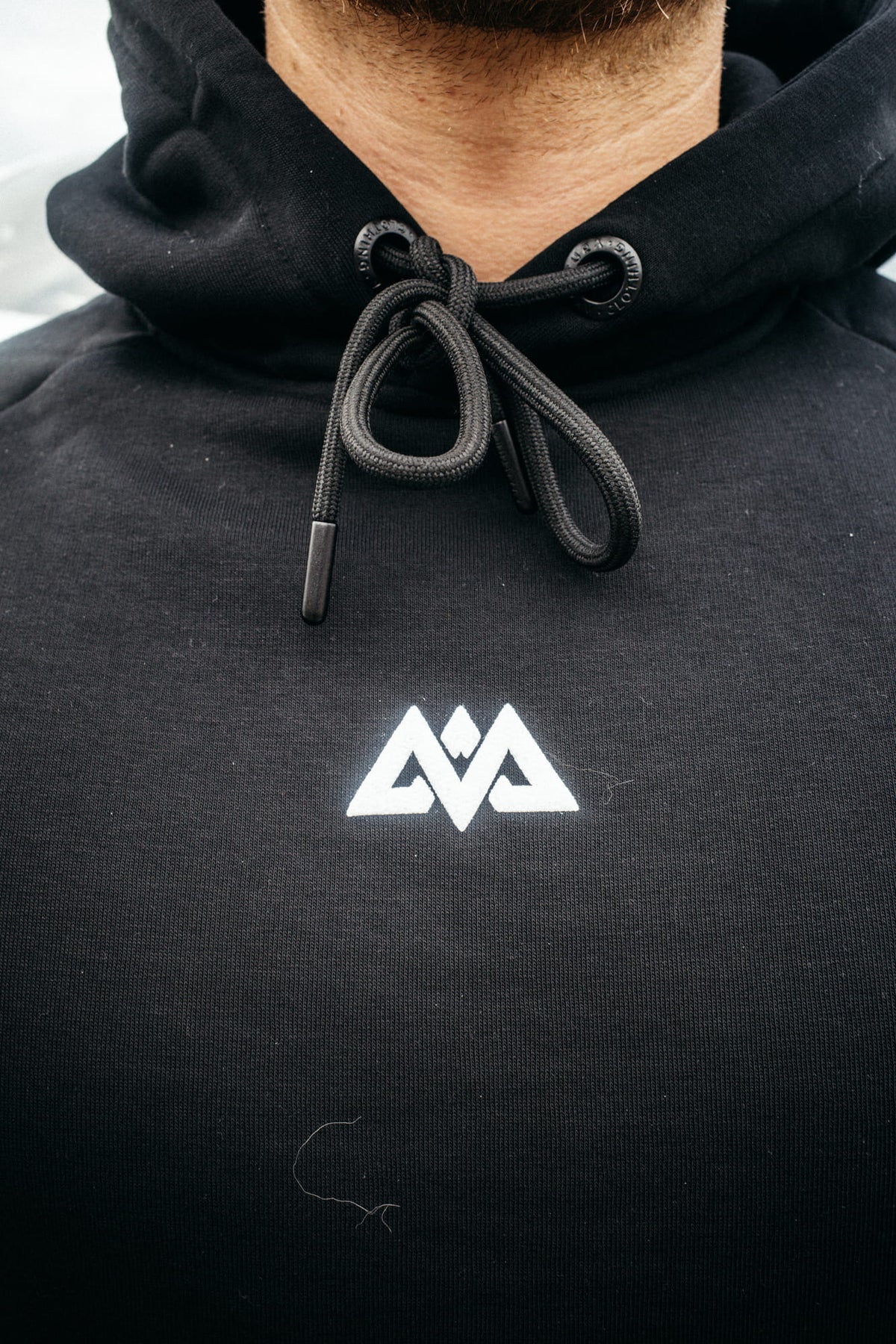 Schwarzer Hoodie weißes Puff-Print Logo mittig Kordelzug Detail