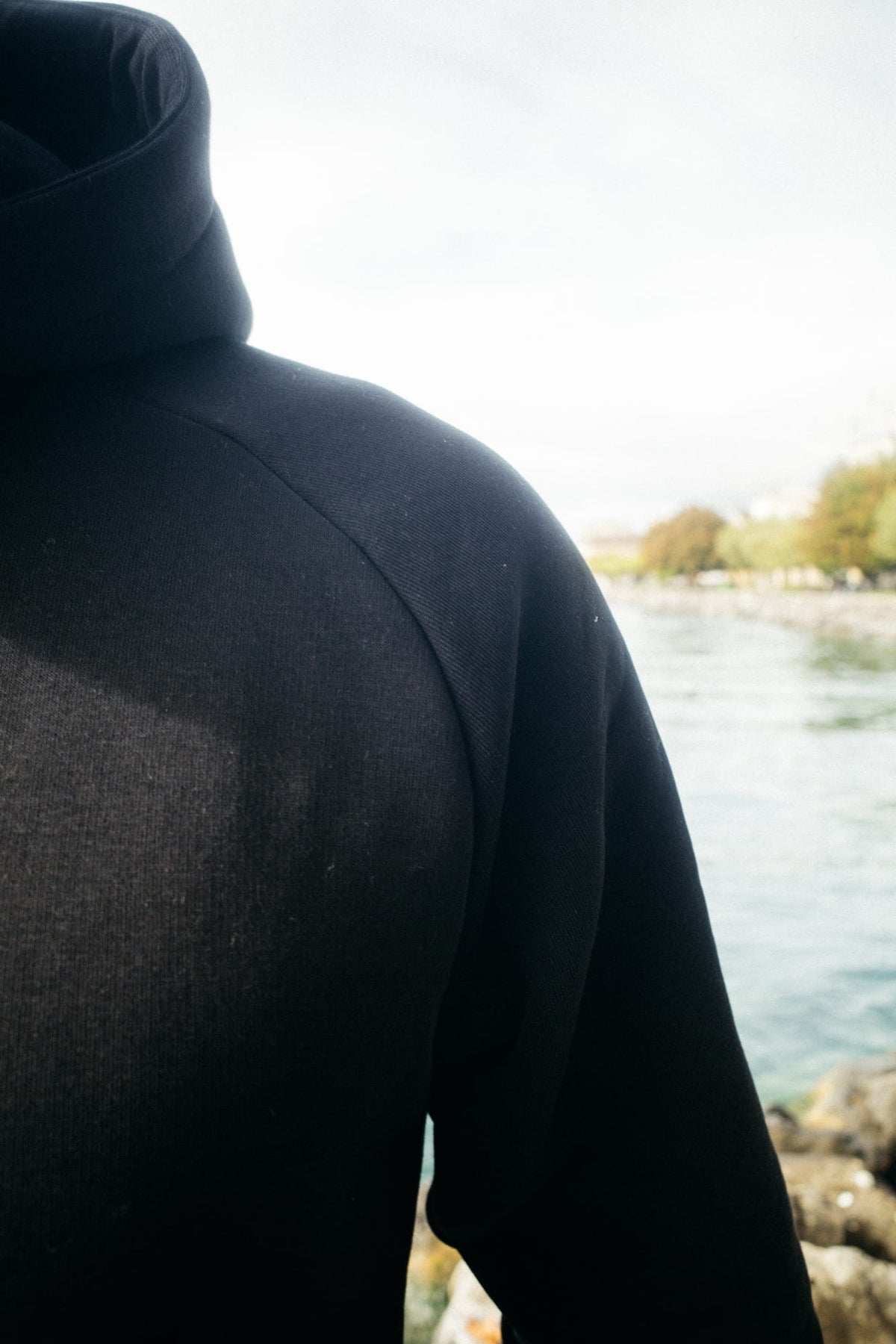 Seitlicher Blick auf schwarzen Hoodie Raglan-Passform Kapuze