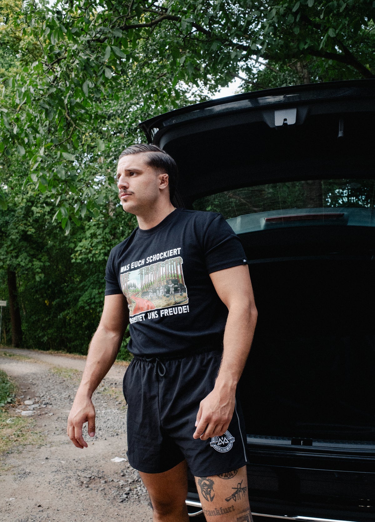Black short-sleeve T-shirt with central German slogan and forest illustration