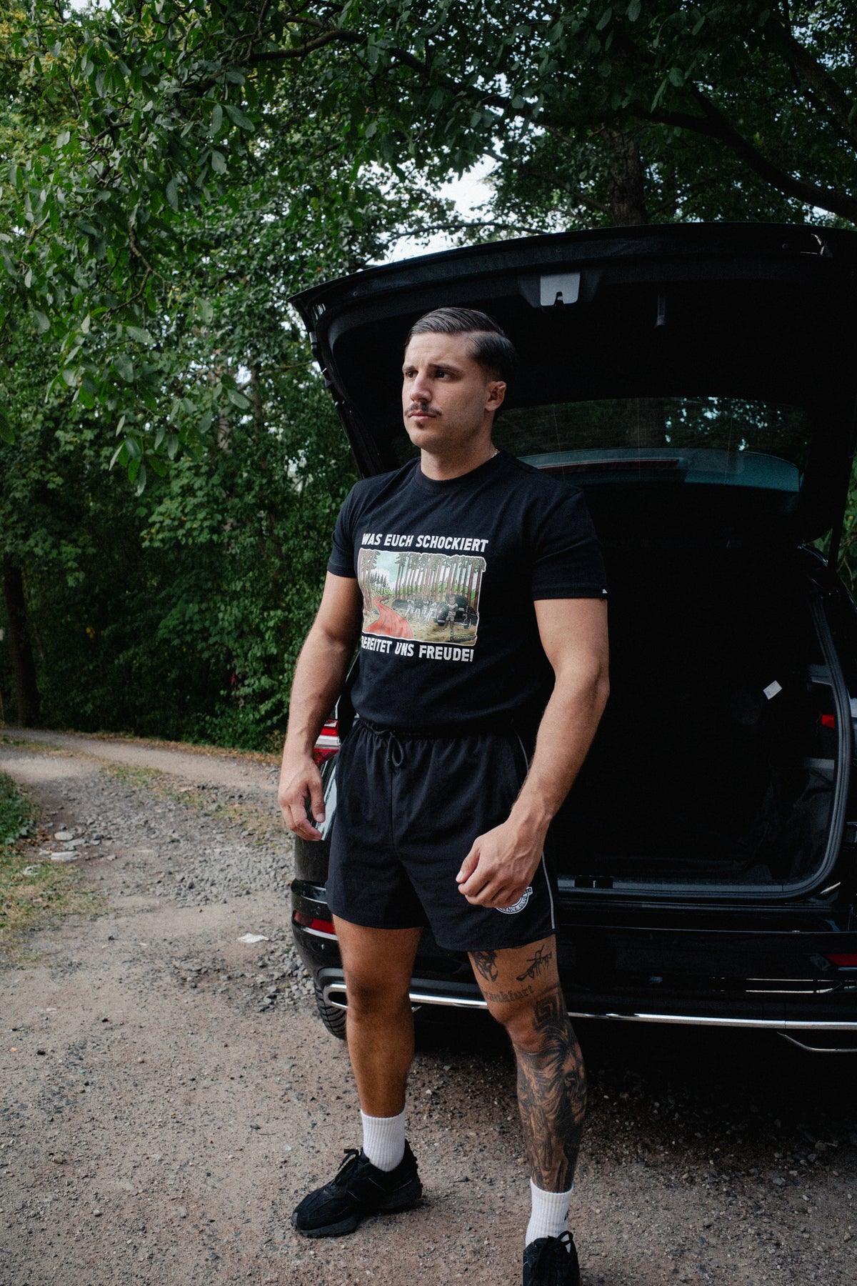 Black Avantura Schock T-shirt with 'WAS EUCH SCHOCKIERT' forest graphic print