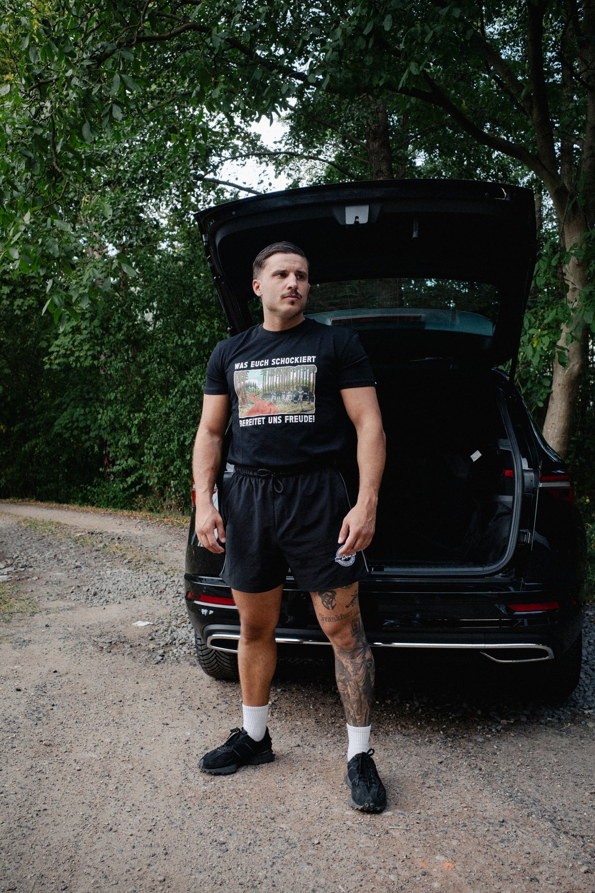 Men's black crewneck T-shirt featuring red road and forest chest design