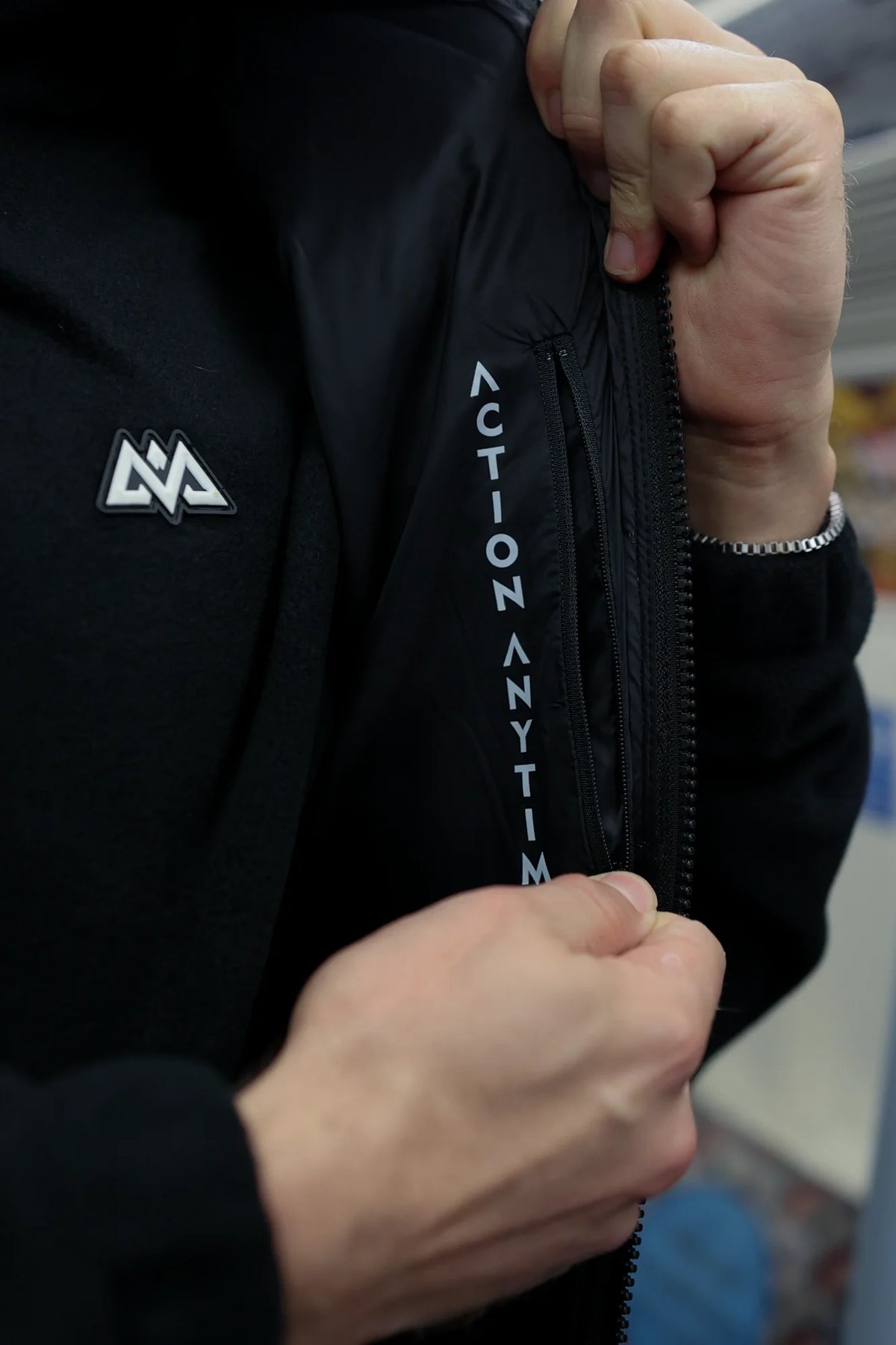 Close-up of zipper opening showing white slogan lining of the down vest