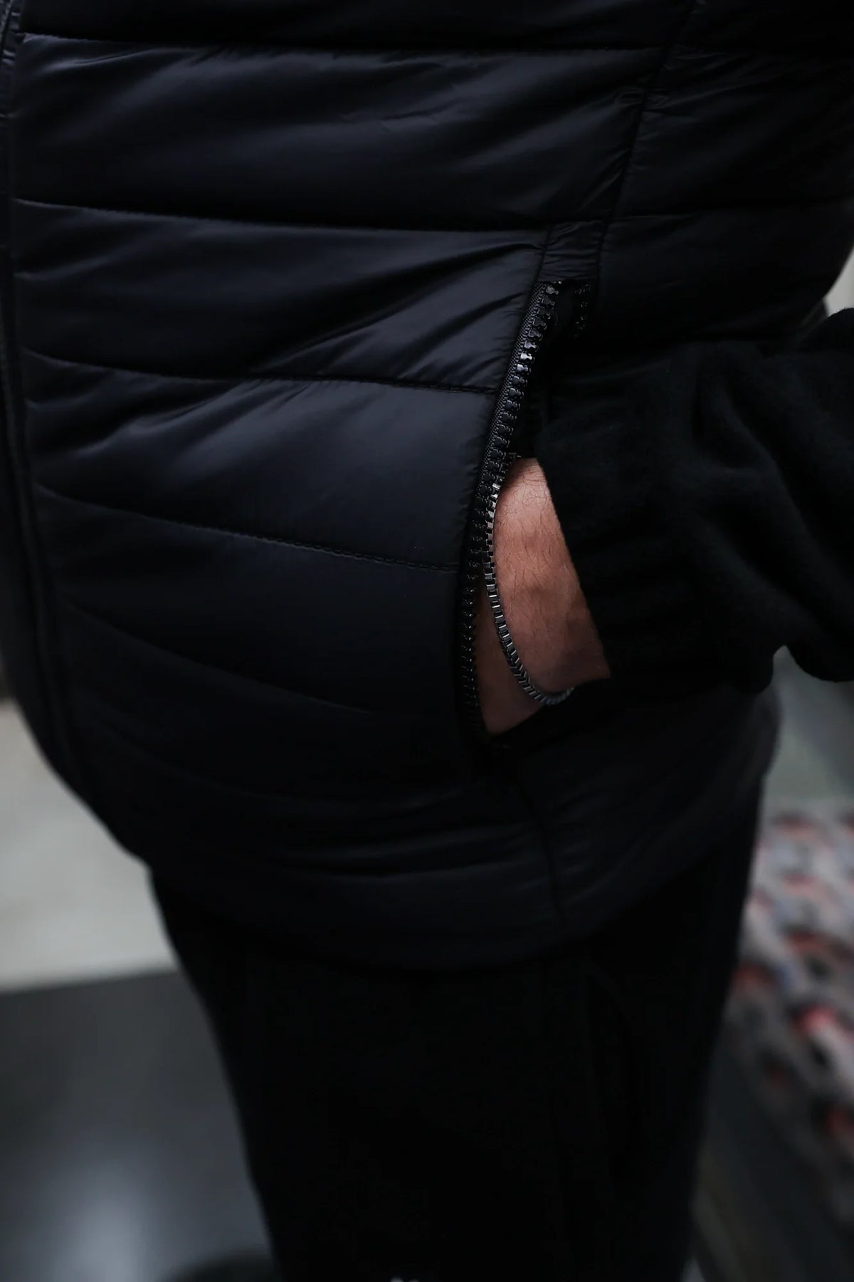 Hand in side zip pocket of horizontally quilted vest