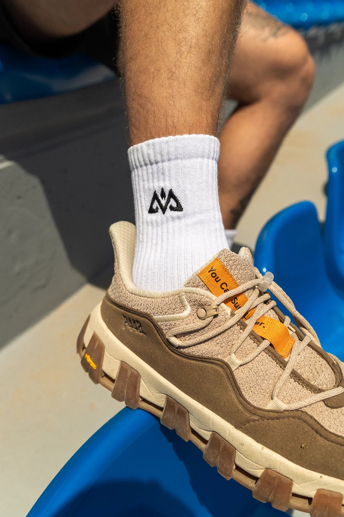 White crew socks with ribbed texture and black embroidered logo detail