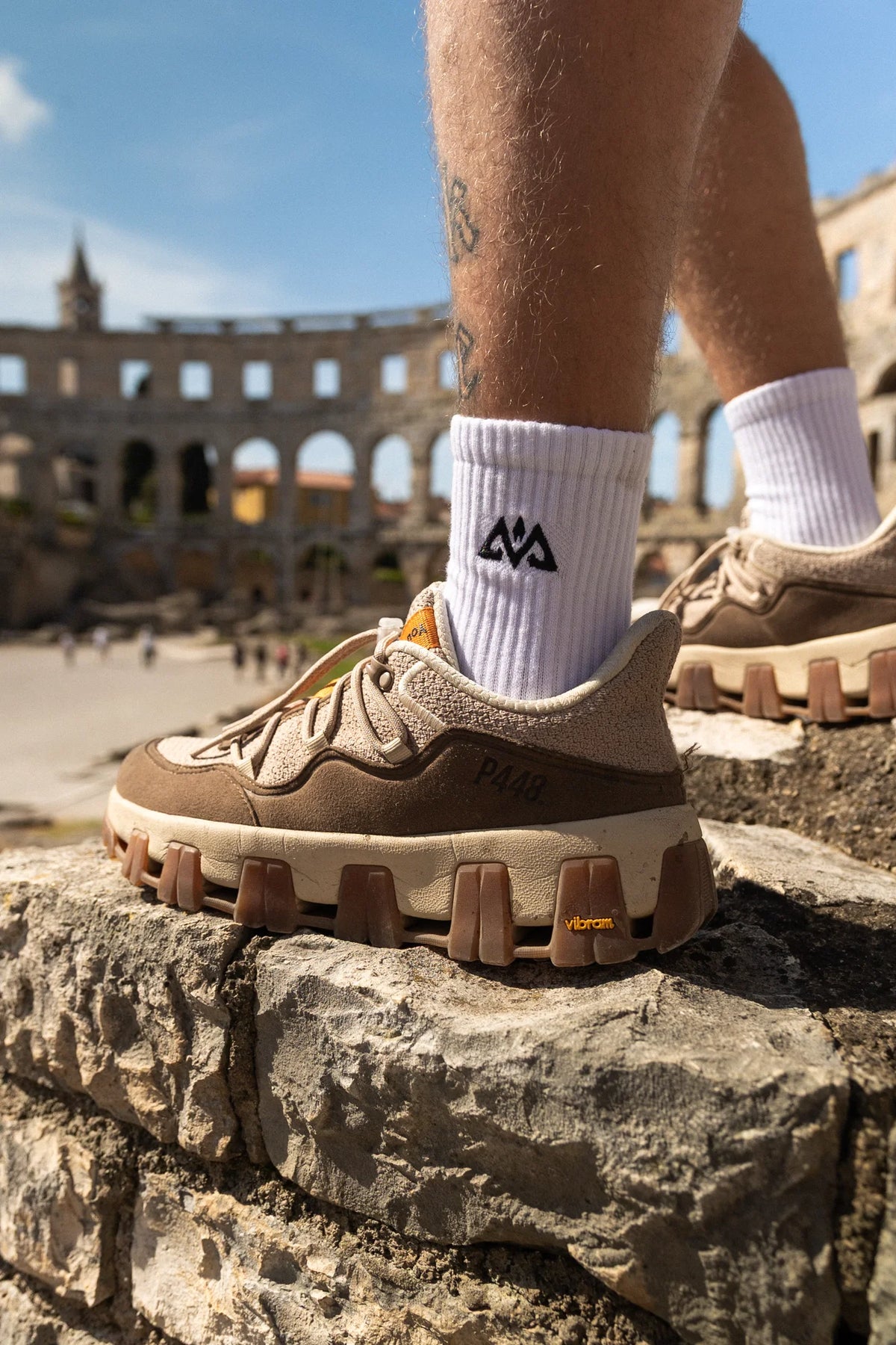 White crew socks worn with beige sneakers on stone steps outdoors