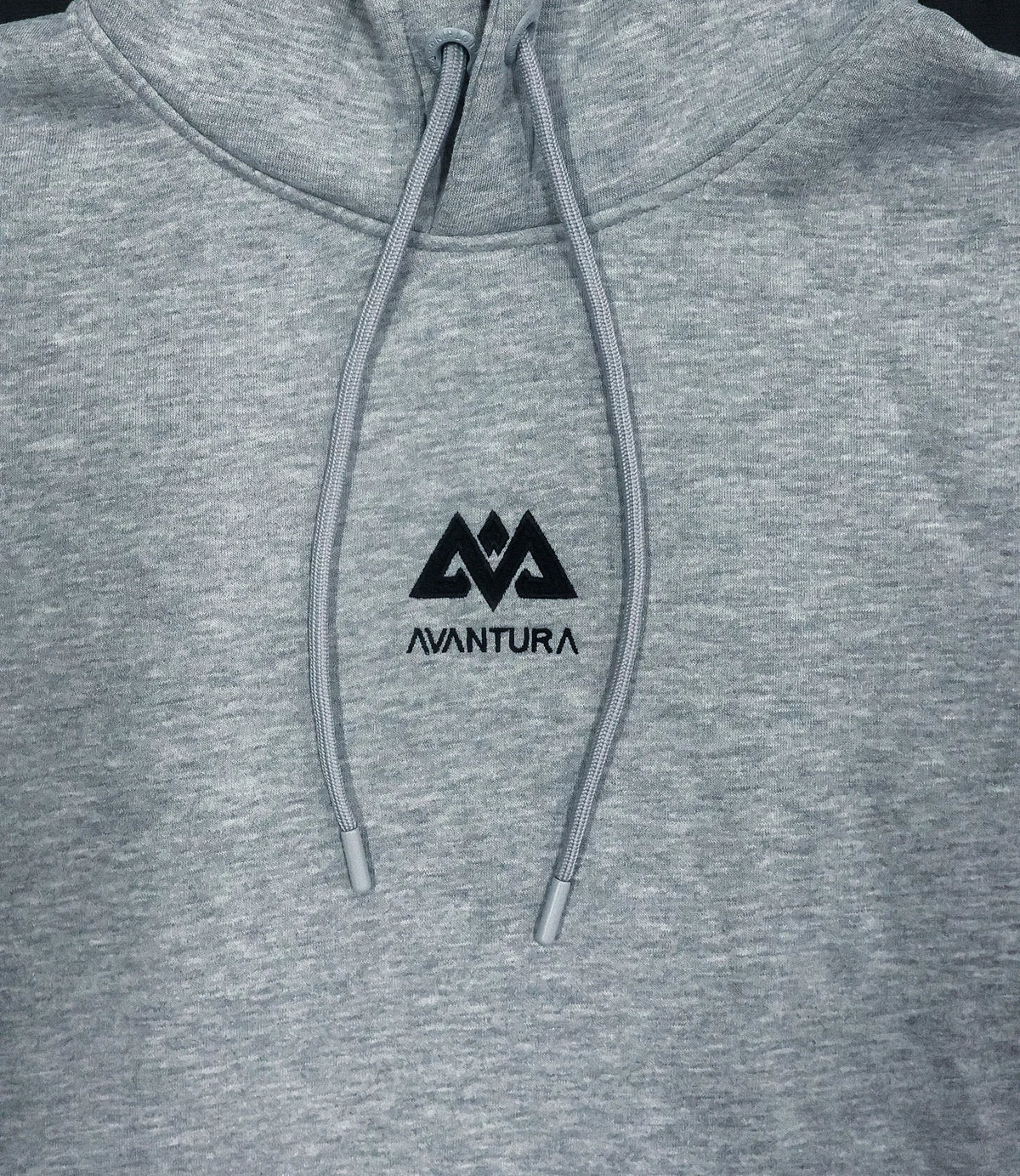 Close-up of embroidered geometric mountain logo and braided drawstrings on grey hoodie